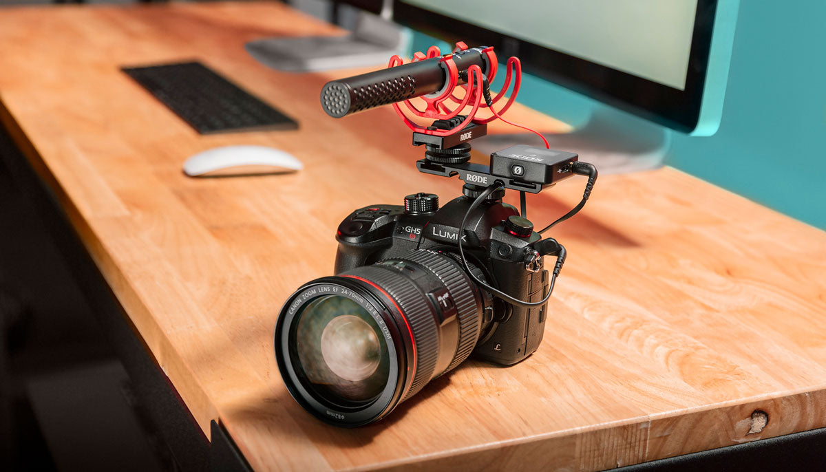 RØDE DCS-1 Dual Cold Shoe Mount on camera in front of screens